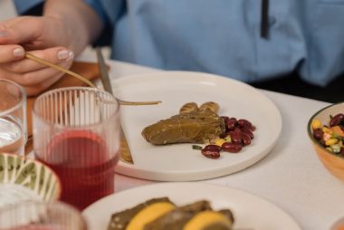 A close-up shot of dolma served with beans and colorful salad, captured during a meal.