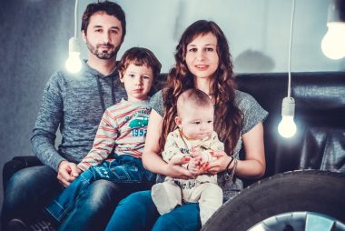 Warm family photo indoors with creative lighting setup, capturing togetherness and joy.
